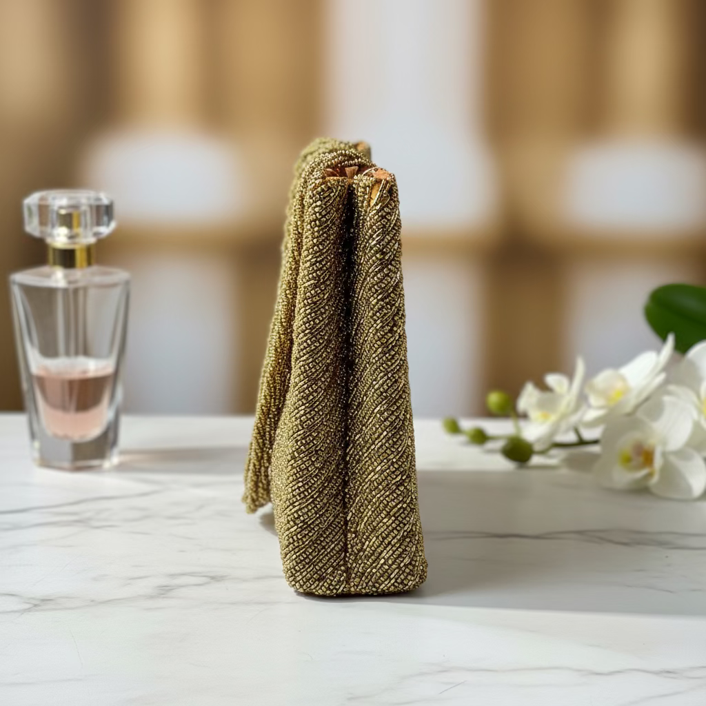 Gold clutch on a marble surface with a blurred background