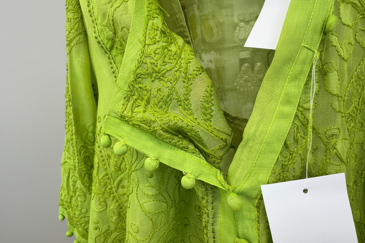 Close-up of green fabric with textured pattern held by a hand