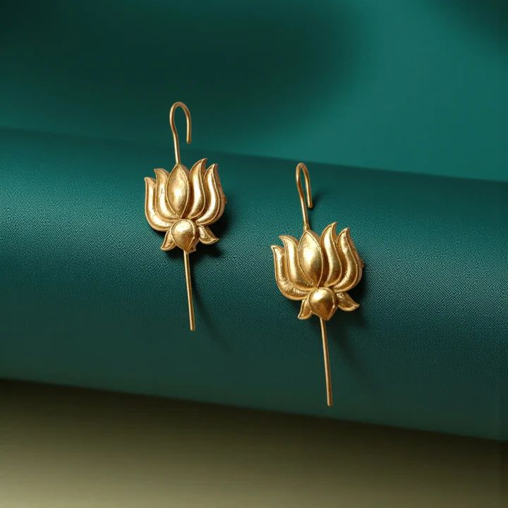 Close-up of lotus-shaped ear cuff earrings on a display, showcasing the gold plating and the long curved wire backing designed for a secure fit.