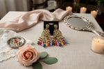 Close-up of rose gold AD stone earrings on a jewellery stand, showcasing multi-colored crystal beads and intricate English jewellery design.