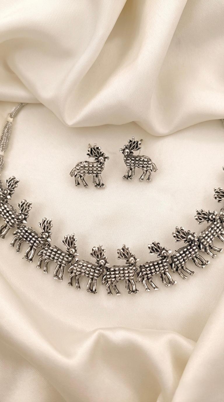 Close-up of the elite deer trail necklace showcasing the intricate silver-coated motifs and antique finish.