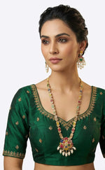 Close-up of the long necklace and earrings showing the intricate multi-color floral pendant and matching chain motifs on a model.