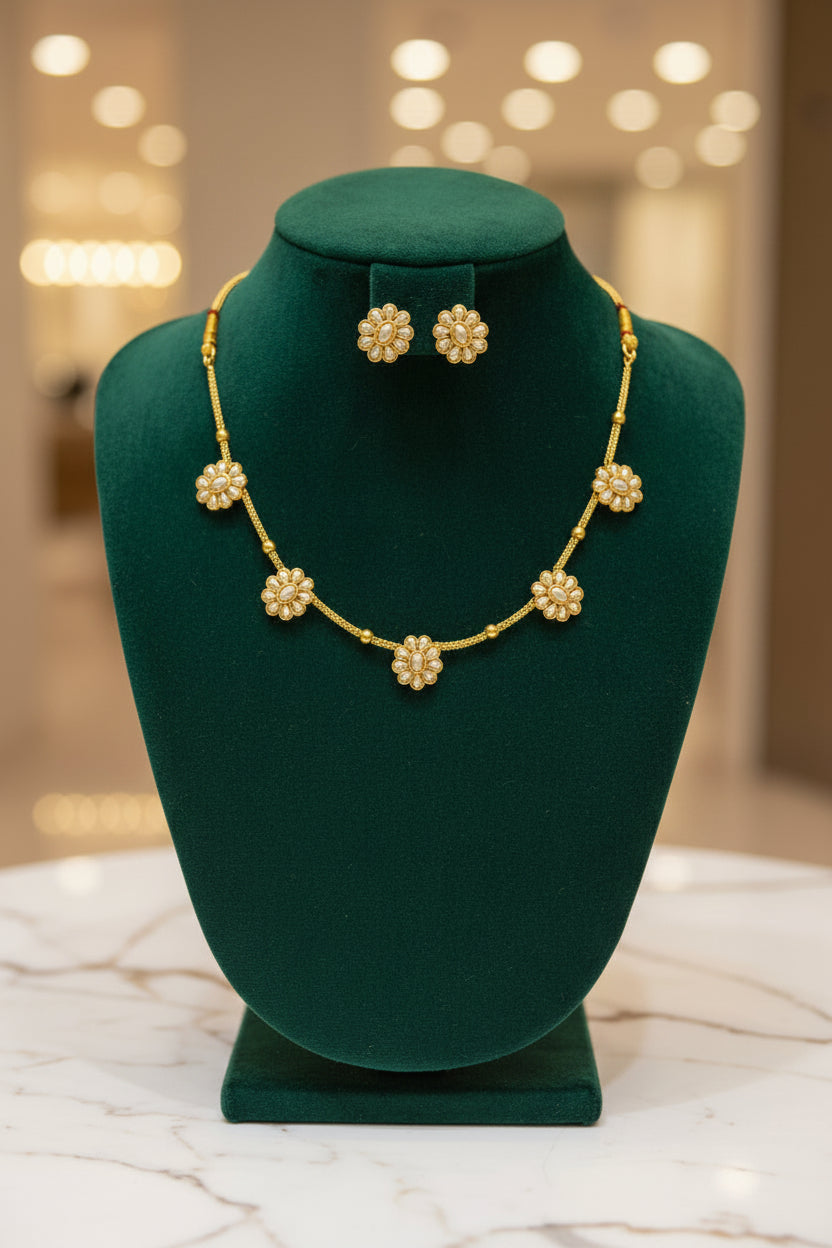  Close-up of the sunburst floral motif featuring a central pearl surrounded by nine petal-shaped seed pearls in a gold setting.