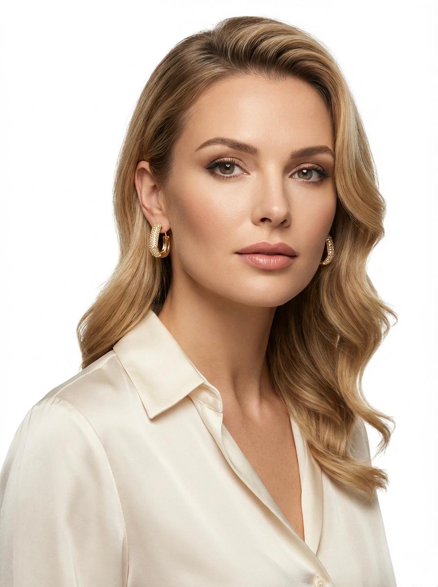  Close-up view of a woman wearing rose gold plated geometric hexagon hoops, showing the sparkling pavé detail and modern silhouette.