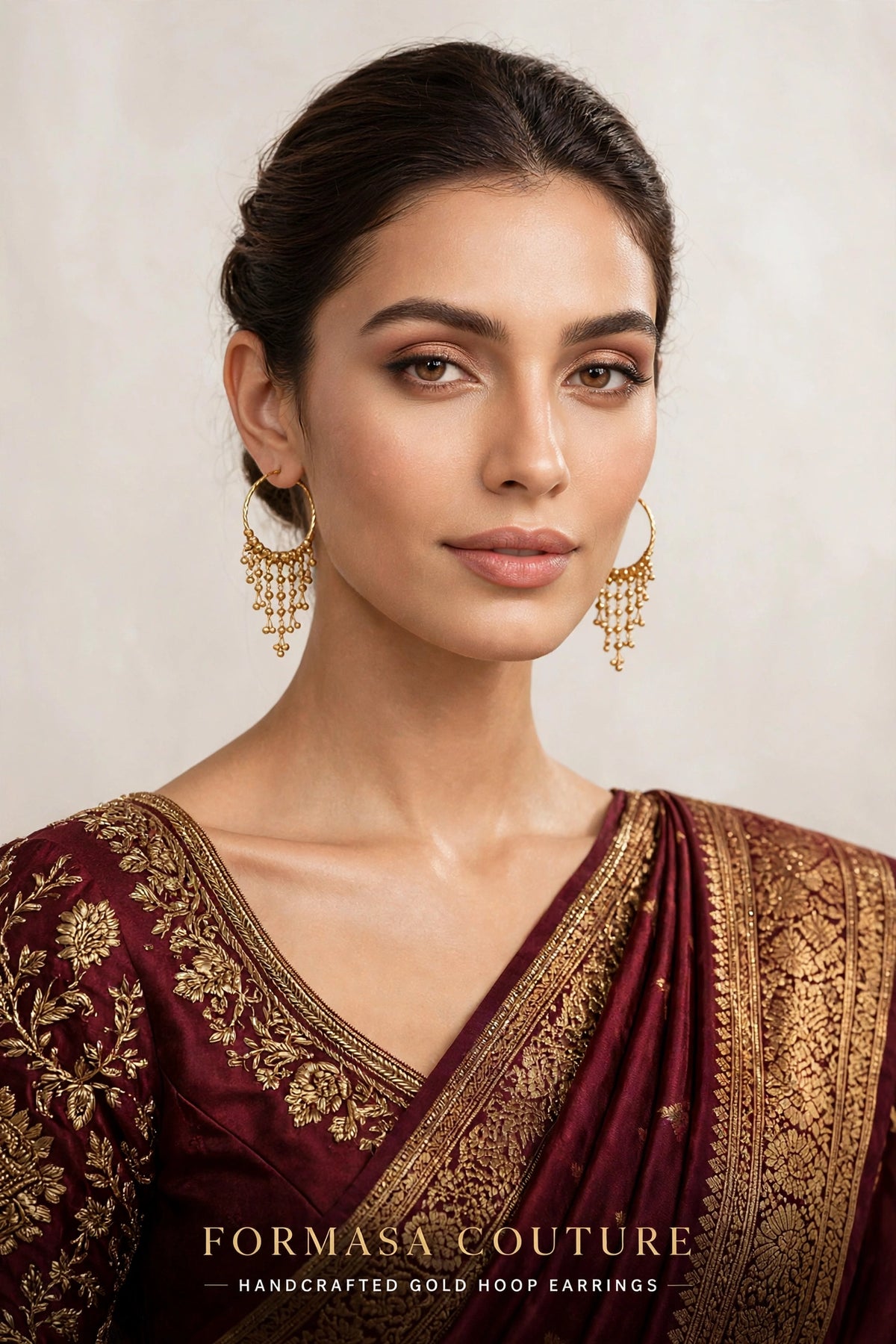 A woman wearing ornate gold hoop earrings with dangling chains, paired with a deep maroon and gold embroidered traditional garment. The brand name 'FORMASA COUTURE' is displayed at the bottom of the image.