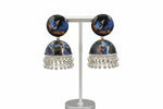 Colorful peacock-themed earrings on a stand.