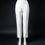 Mannequin display focusing on the matching white trousers of the co-ord set, featuring subtle embroidery detail at the hems against a dark background.