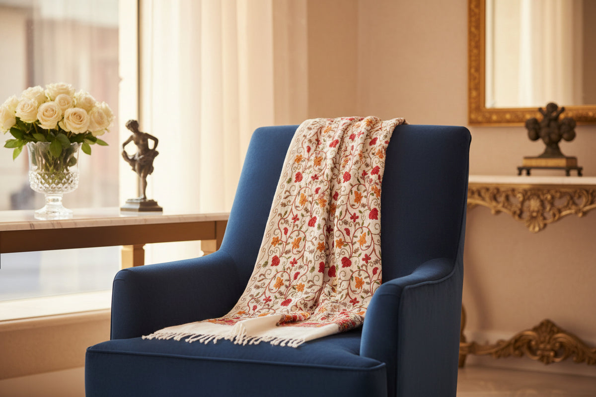 Decorative white scarf with red and orange floral pattern on a gray background