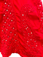Close-up view of intricate red paisley embroidery and delicate sequin work on a crimson sharara fabric.