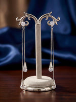  Detailed shot of the 10cm Celestial silver AD statement earrings on a display stand, showing the triple-tier stone drop design.