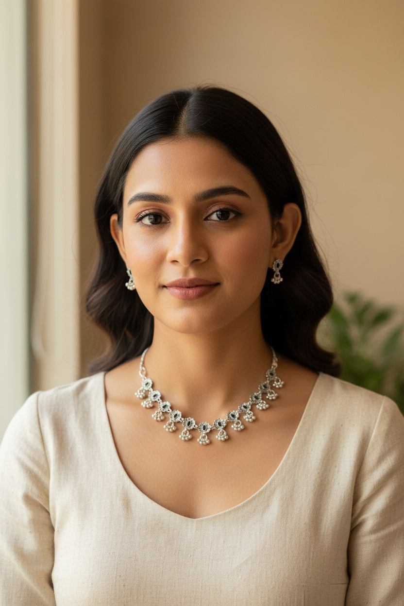 Detailed shot of the intricate symmetrical floral engravings and polished black stone centers on the antique silver-finish necklace.