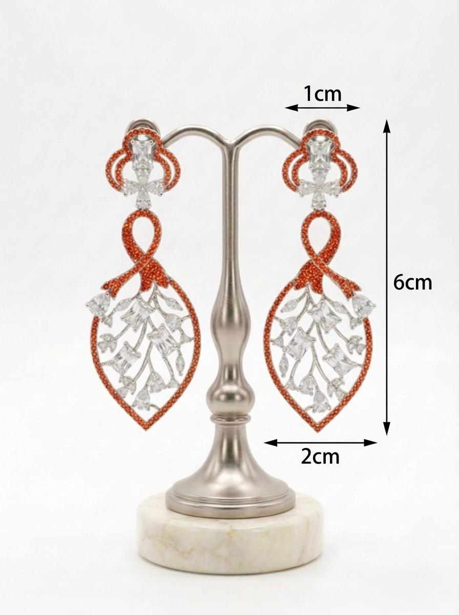 Detailed studio view of the Orange American Diamond leaf-motif dangles, highlighting the 2cm width and shimmering stone-encrusted frame.