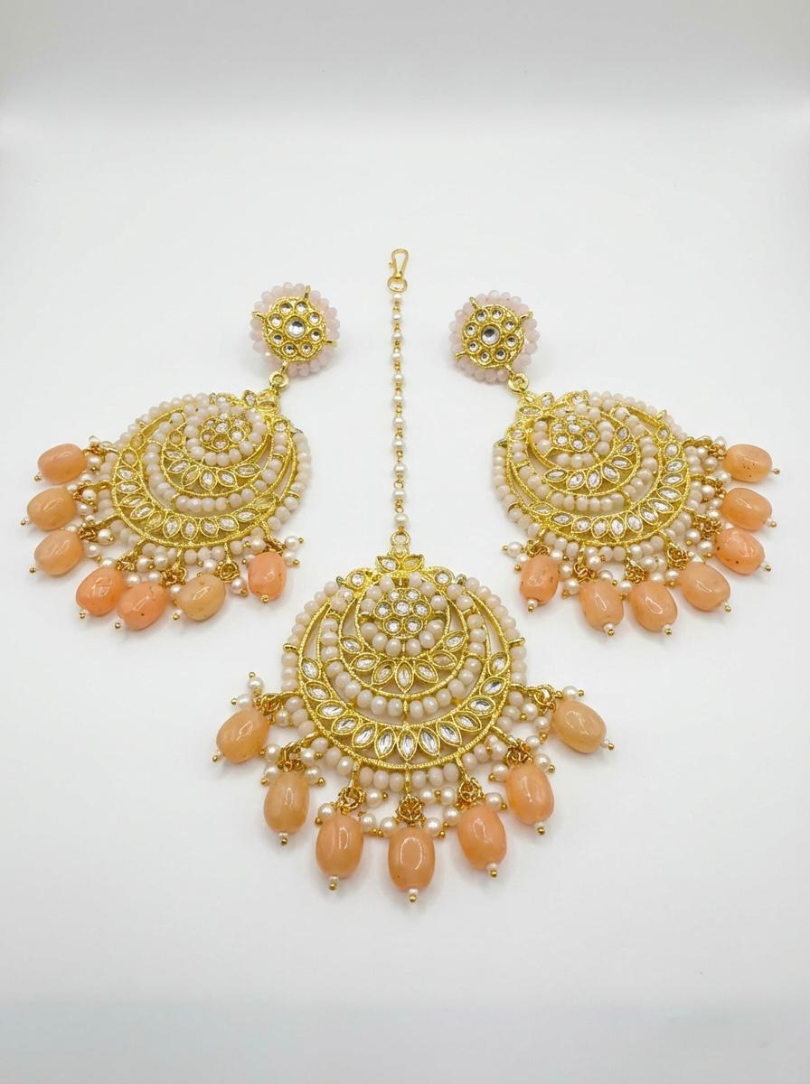  Detailed view of circular rose gold-toned statement earrings featuring peach accents and traditional kundan stonework.