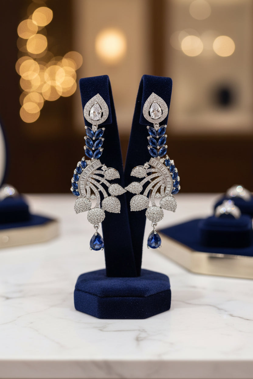 Earrings featuring leaf elements, with blue sapphire stones and American diamonds. Party wear posh jewellery set. 