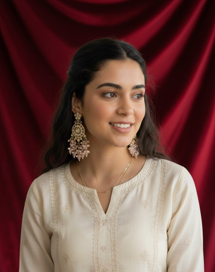 Elegant model wearing statement rose gold American Diamond earrings against a rich red velvet background, highlighting the posh jewellery aesthetic for modern wedding guests.
