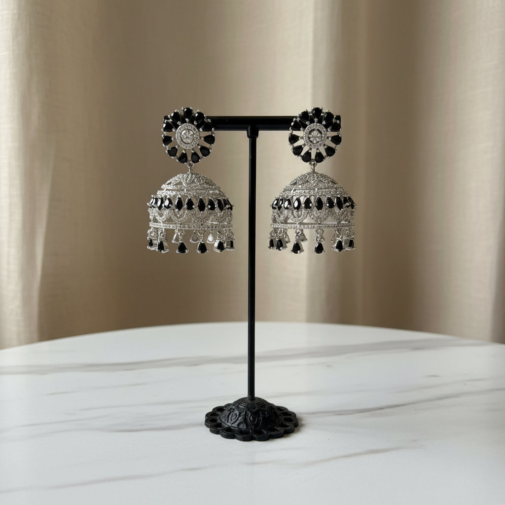  Elegant silver-plated Indian jhumke with striking black crystal accents arranged in a floral stud and dome pattern.