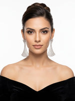 Elegant silver statement chandelier earrings with a geometric flared fan design, fully paved in brilliant white crystals, worn by a model in a black off-the-shoulder dress.