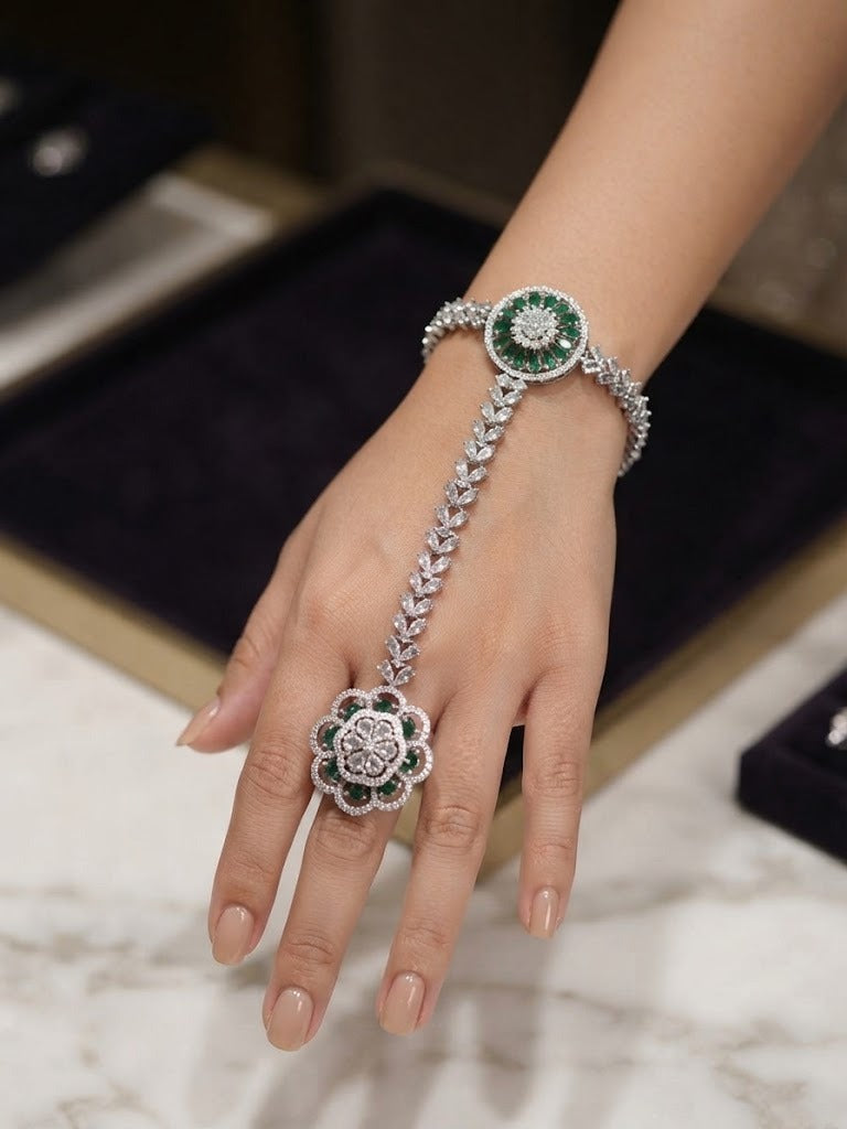 Emerald green & clear zircon silver-plated hathphool hand harness — bracelet with connected floral ring, luxury bridal jewelry on hand model.