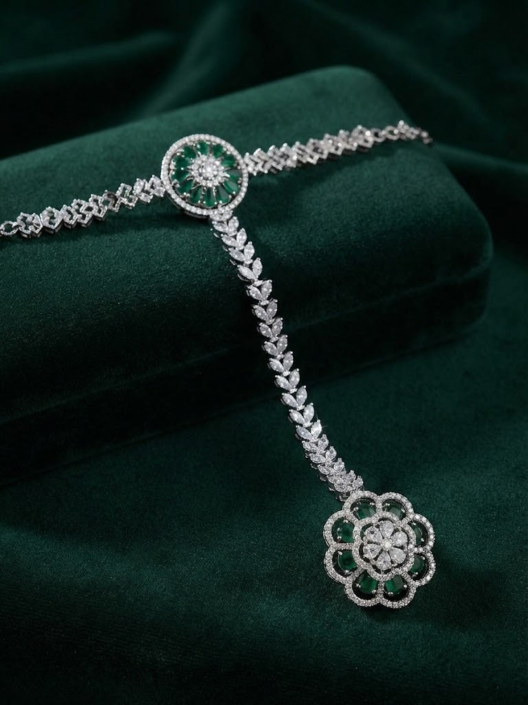 Emerald green & clear zircon silver-plated hathphool hand harness — flat lay on deep green velvet, luxury bridal jewelry.