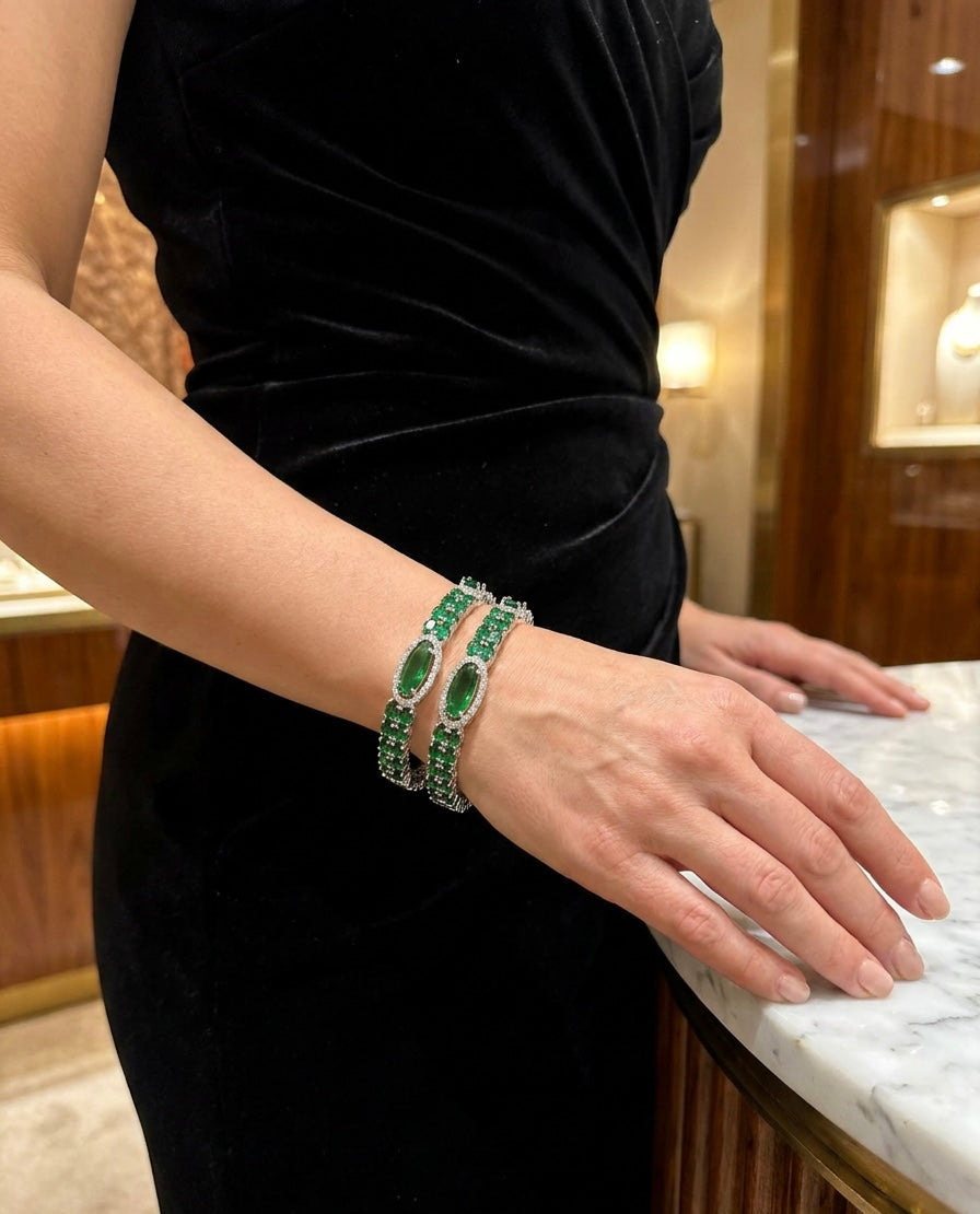 Emerald green American diamond oval cuff bangles – 2-piece silver plated set with green stones and clear diamond halo on female wrist