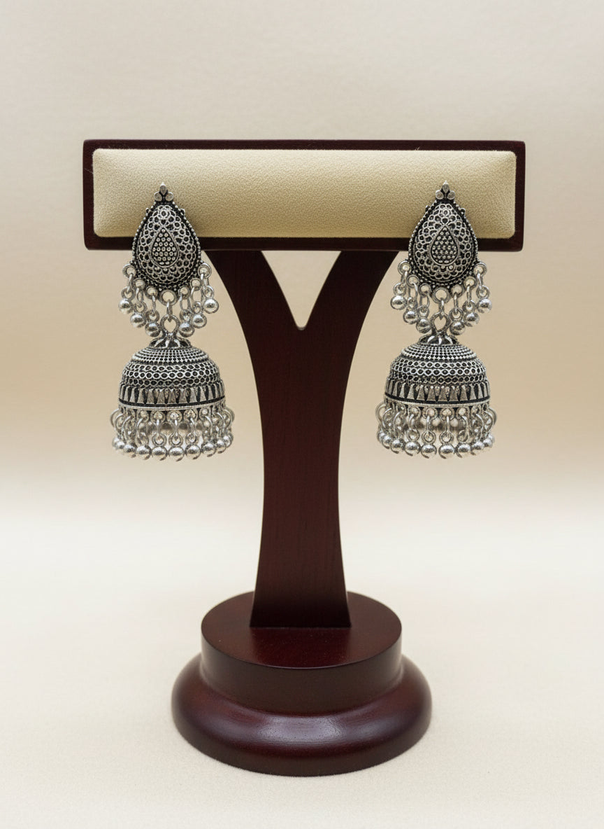 Close up of oxidised silver hoop with filigree pattern