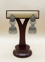 Close up of oxidised silver hoop with filigree pattern