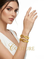A woman wears a stylish set of two micro gold-plated interlocking swirl bangles