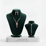 A luxury jewelry set from Famaza Couture featuring a dainty floral zircon necklace and matching floral stud earrings, presented on a dark velvet stand in a rose gold finish.