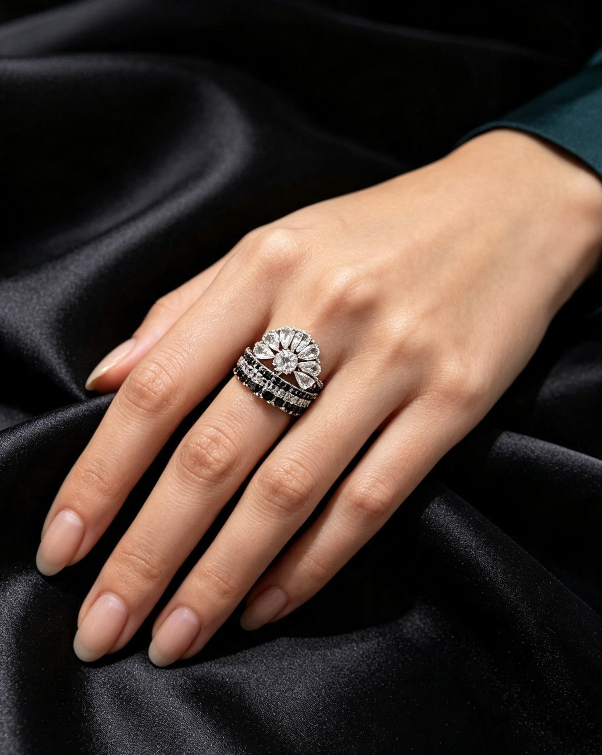 Fan Halo Tiered Ring with white crystal fan halo and silver & black multi-tiered band, luxury designer jewelry worn on hand against black satin