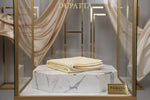 Folded fabric on a marble stand with 'FAMAZA' branding in a decorative setting.