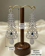 Pair of silver earrings with blue stones on a wooden stand, showing measurements.