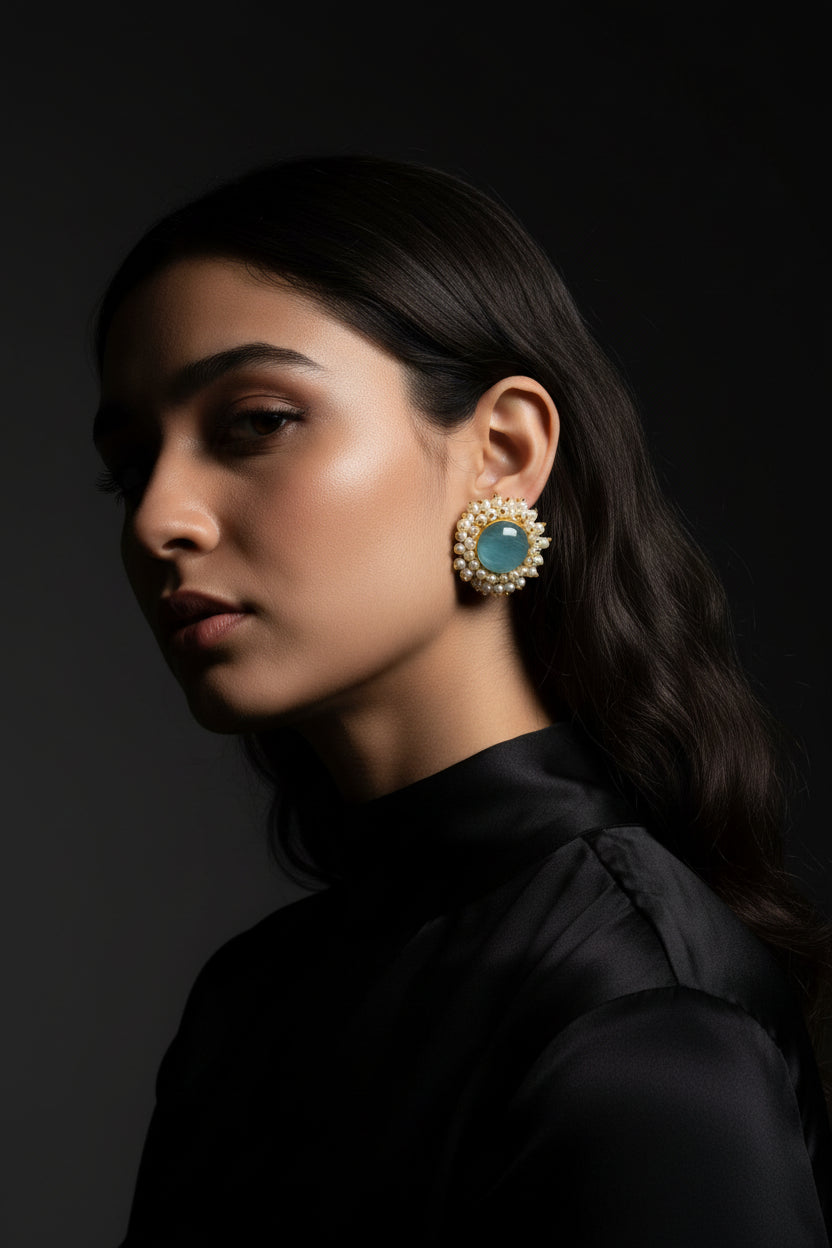 Girl wearing sky blue Mona Lisa stone studs with nano pearls, vibrant golden earrings for summer weddings and posh parties.