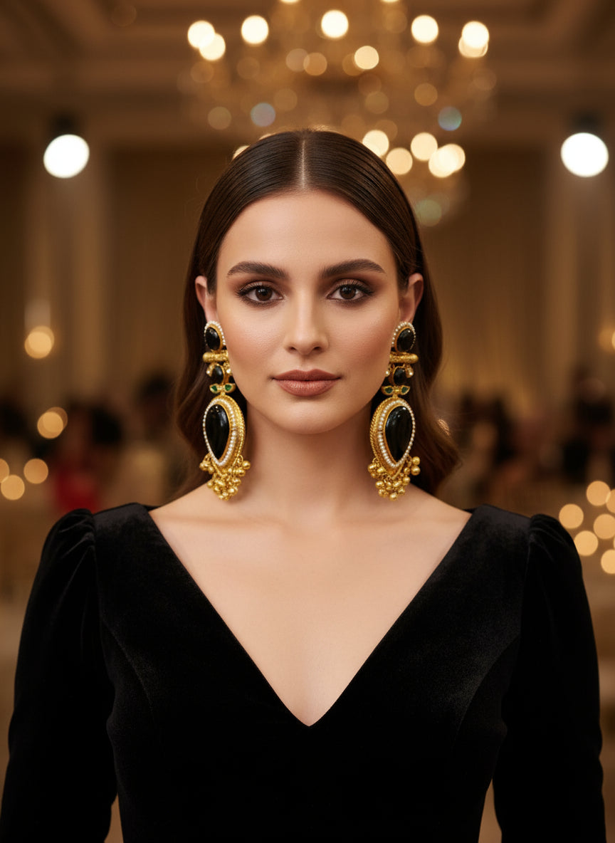 Gold and black jewellery set on a textured white surface