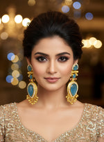 Gold and blue gemstone jewellery on a white fur surface