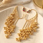 Gold earrings with intricate designs on a white plate