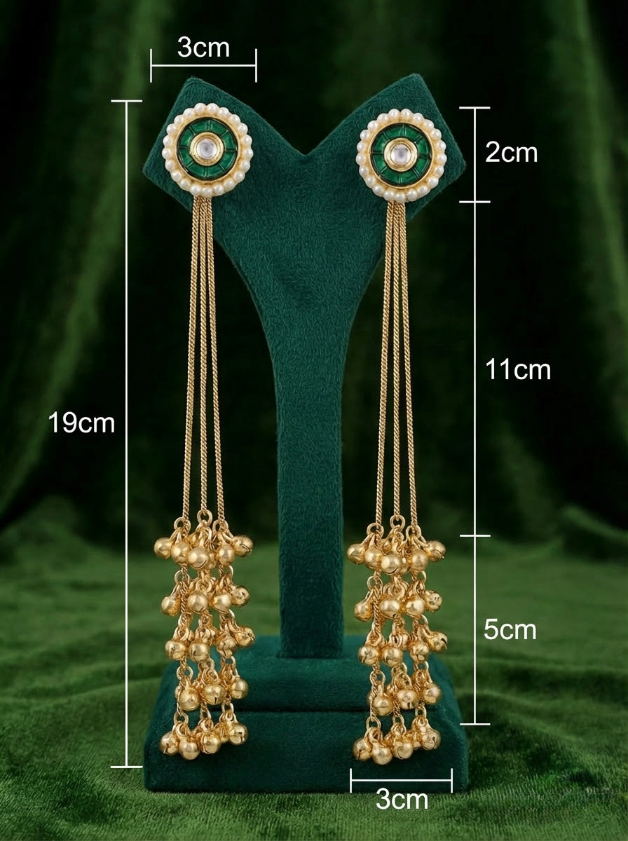 Gold earrings with measurements on a green stand against a green background