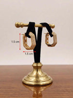 Gold hoop earrings on a stand with measurements indicated