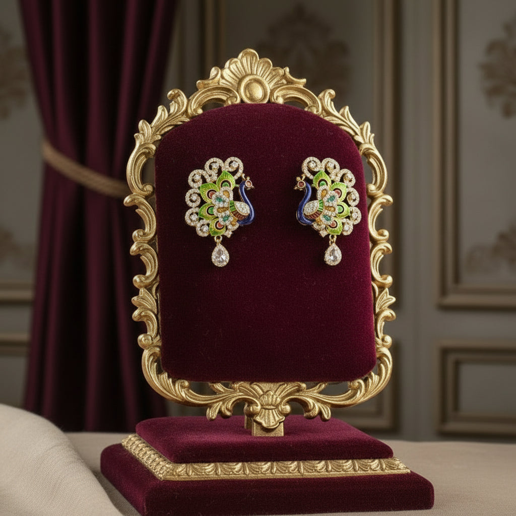 Gold polished peacock figure earrings with vibrant green, blue, and gold enamel accents, along with sparkling white ad stones embellishments. Earrings are focused to show the design.