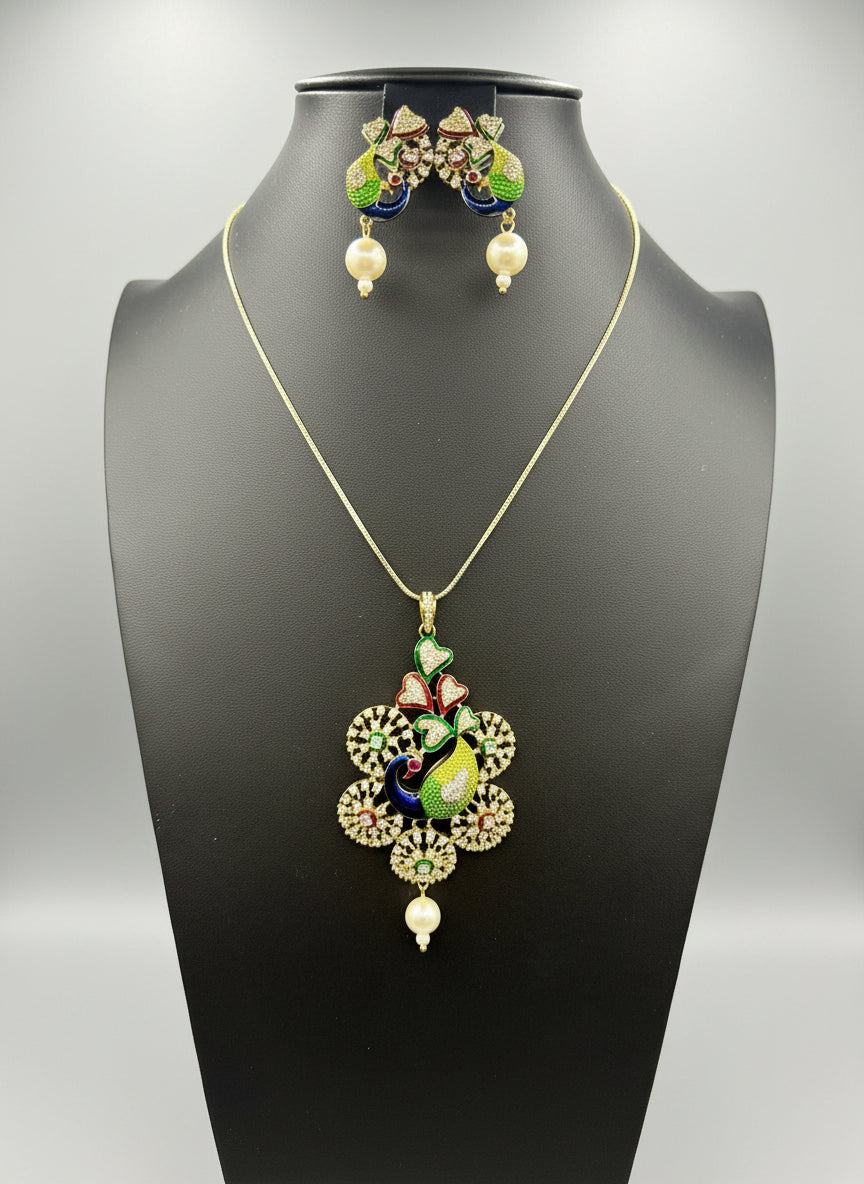Gold polished a peacock pendant with vibrant green, blue, and gold enamel accents, along with white ad stones sparkling embellishments, accompanied by matching earrings. Party wear jewellery set. 