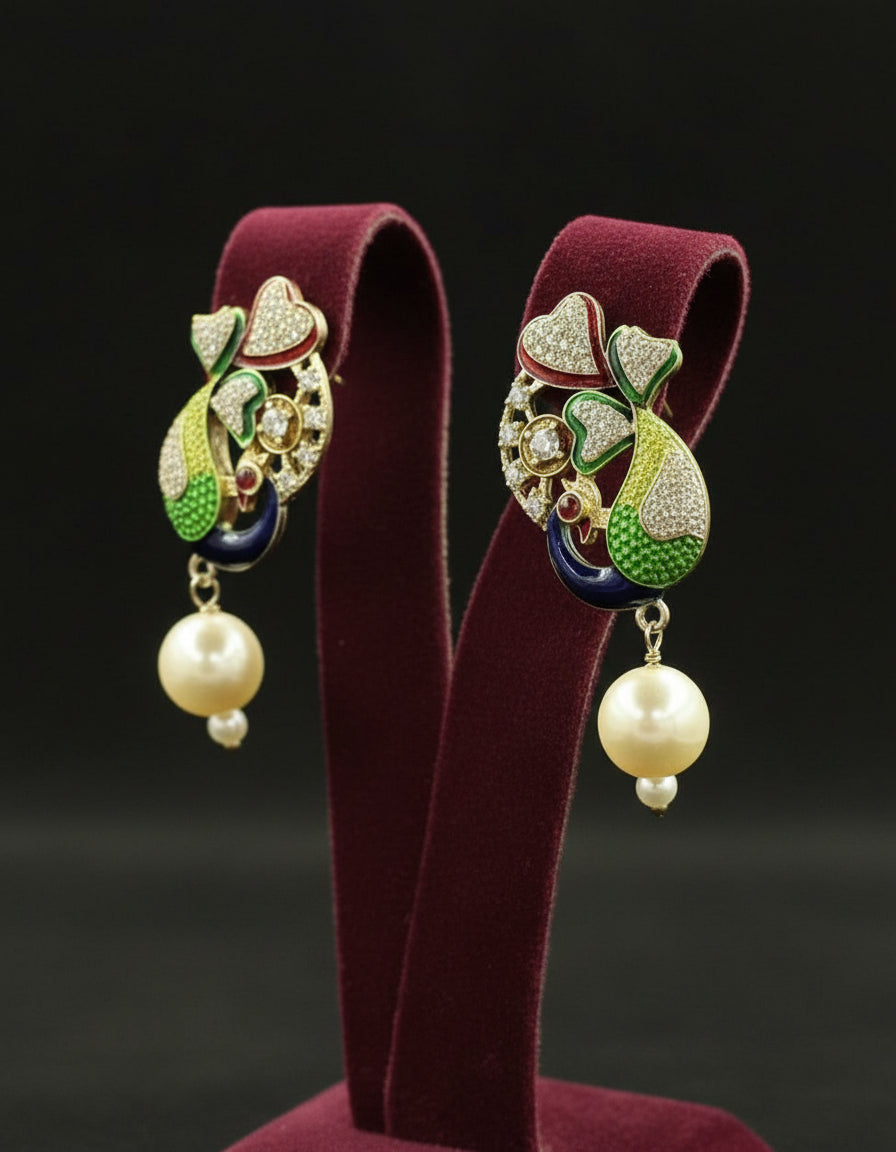 Gold polished peacock figureearrings with vibrant green, blue, and gold enamel accents, along with sparkling white ad stones embellishments. Earrings are focused to show the design.
