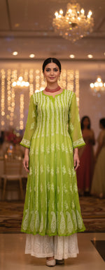 Green dress with floral patterns on a mannequin in a store setting
