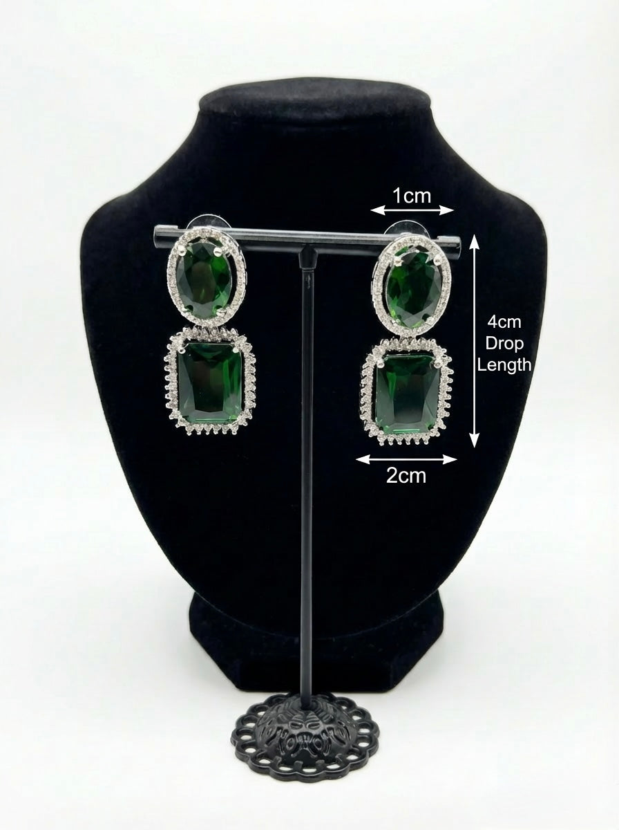 Green gemstone earrings on a black bust with measurements displayed.