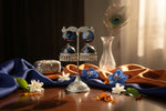 Hand-painted peacock motif jhumka earrings with vibrant blue and orange feathers on a black base.