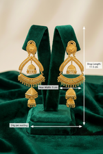 Gold earrings on a green stand with measurements indicated