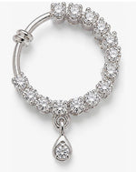 A silver-toned huggie hoop earring adorned with round-cut clear crystals and featuring a dangling teardrop-shaped crystal cluster charm, shown on a light gray background.