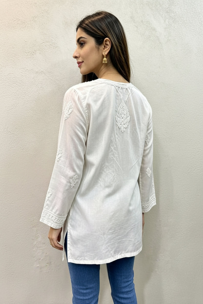Back view of a woman wearing an ivory white cotton kurti featuring delicate white embroidery on the back and sleeves, paired with a square hem line.