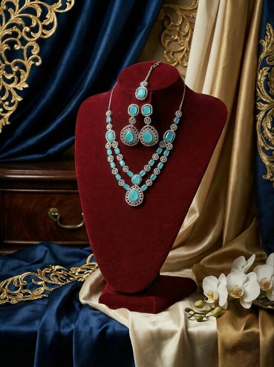 Jewellery set with turquoise stones on a red velvet stand against decorative fabric background