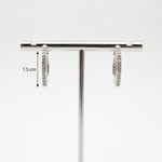 Jewellery stand with two pairs of silver stud earrings on a white background