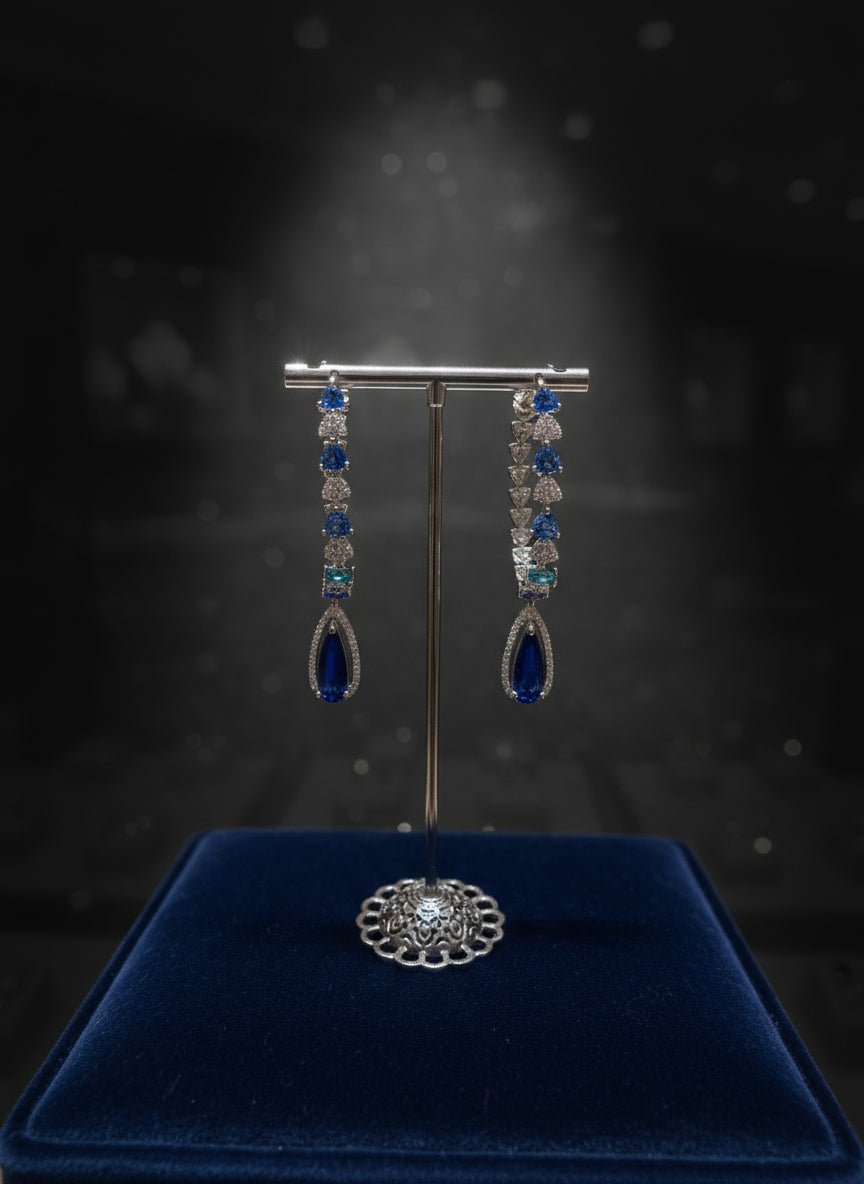 Jewelry display with blue gemstone earrings on a dark background