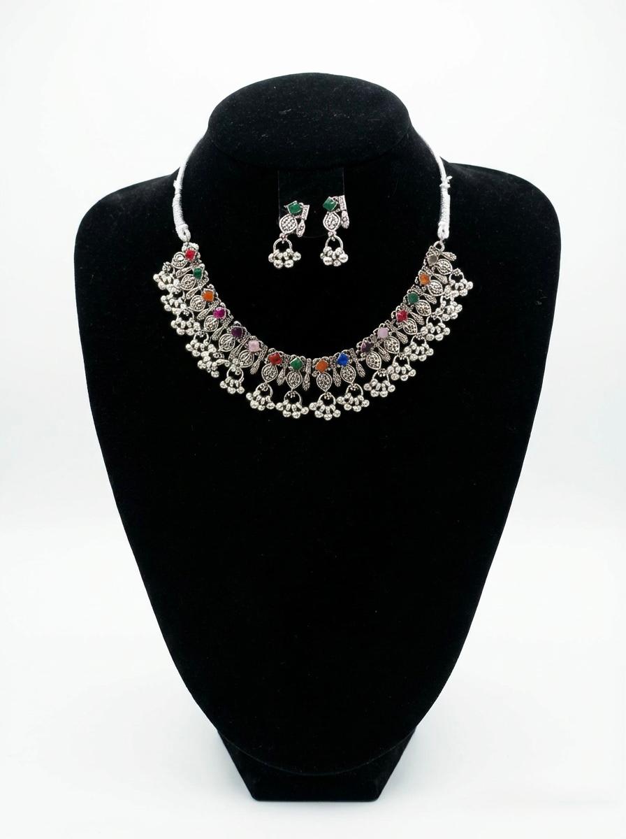 Jewelry set with necklace and earrings on a black stand against a white background
